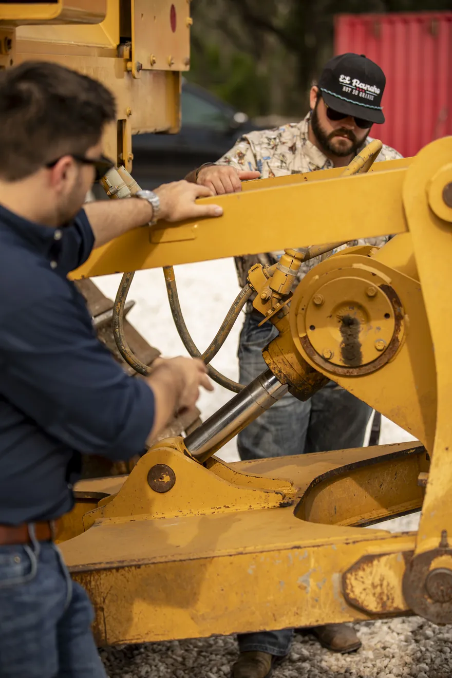 Attachments and parts staged near a piece of heavy equipment