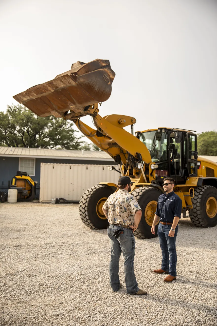 Rental yard with backhoes and loaders staged for dispatch