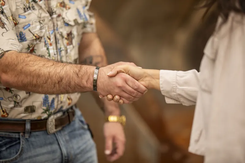 A handshake closing a deal in front of heavy equipment